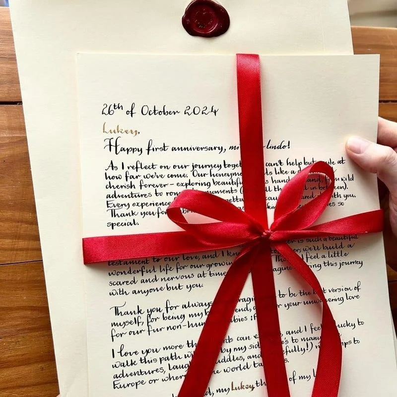 Handwritten anniversary love letter tied with a red ribbon and sealed with a red wax stamp